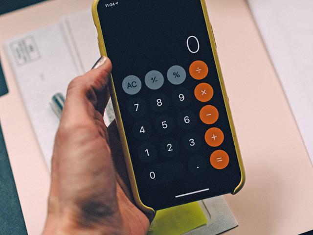female hand holding an android with calculator screen