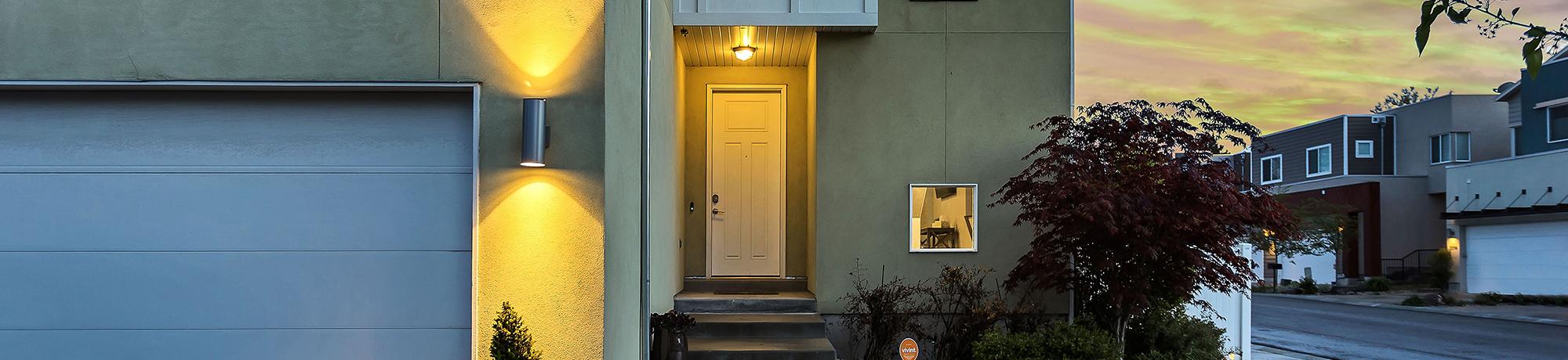 front of a home at dusk with the porch light on